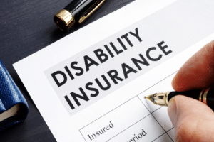 A man's hand completing a disability insurance form