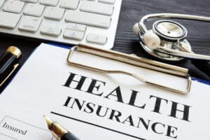 A stethoscope and health insurance form