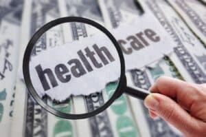 A magnifying glass highlights the word healthcare on a piece of paper