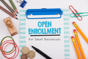 A paper on a clipboard reads "Open Enrollment for Small Businesses"